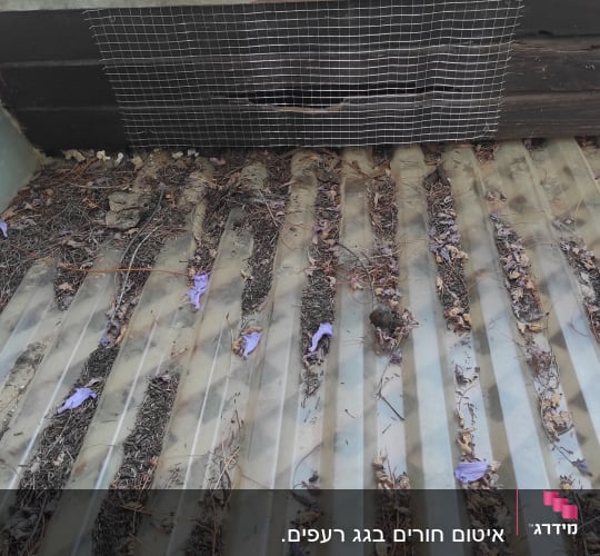 רעפים חומים עם רשת מתכת על הגג